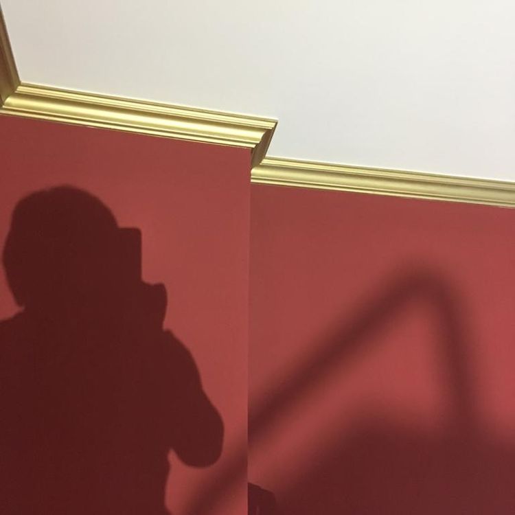 Schattenumriss einer Person an einer rot gestrichenen Wand